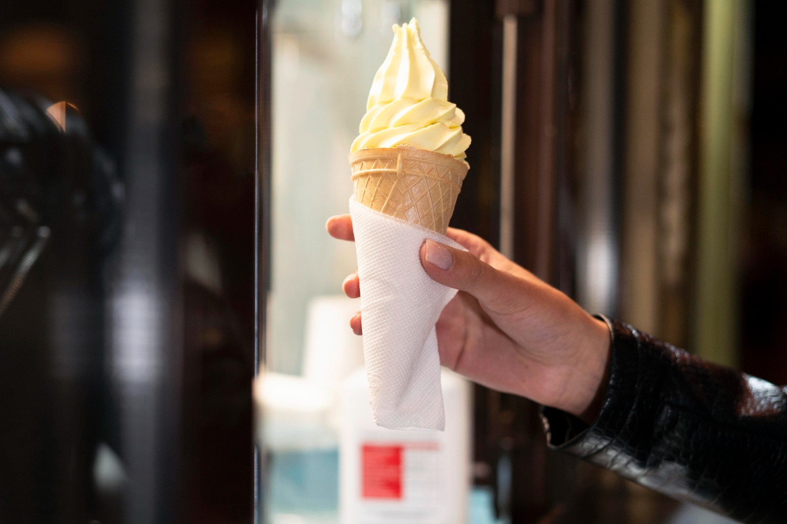 hand holding ice cream Woman outdoor at summer sunset time having ice cream cone positive happy playful at city street