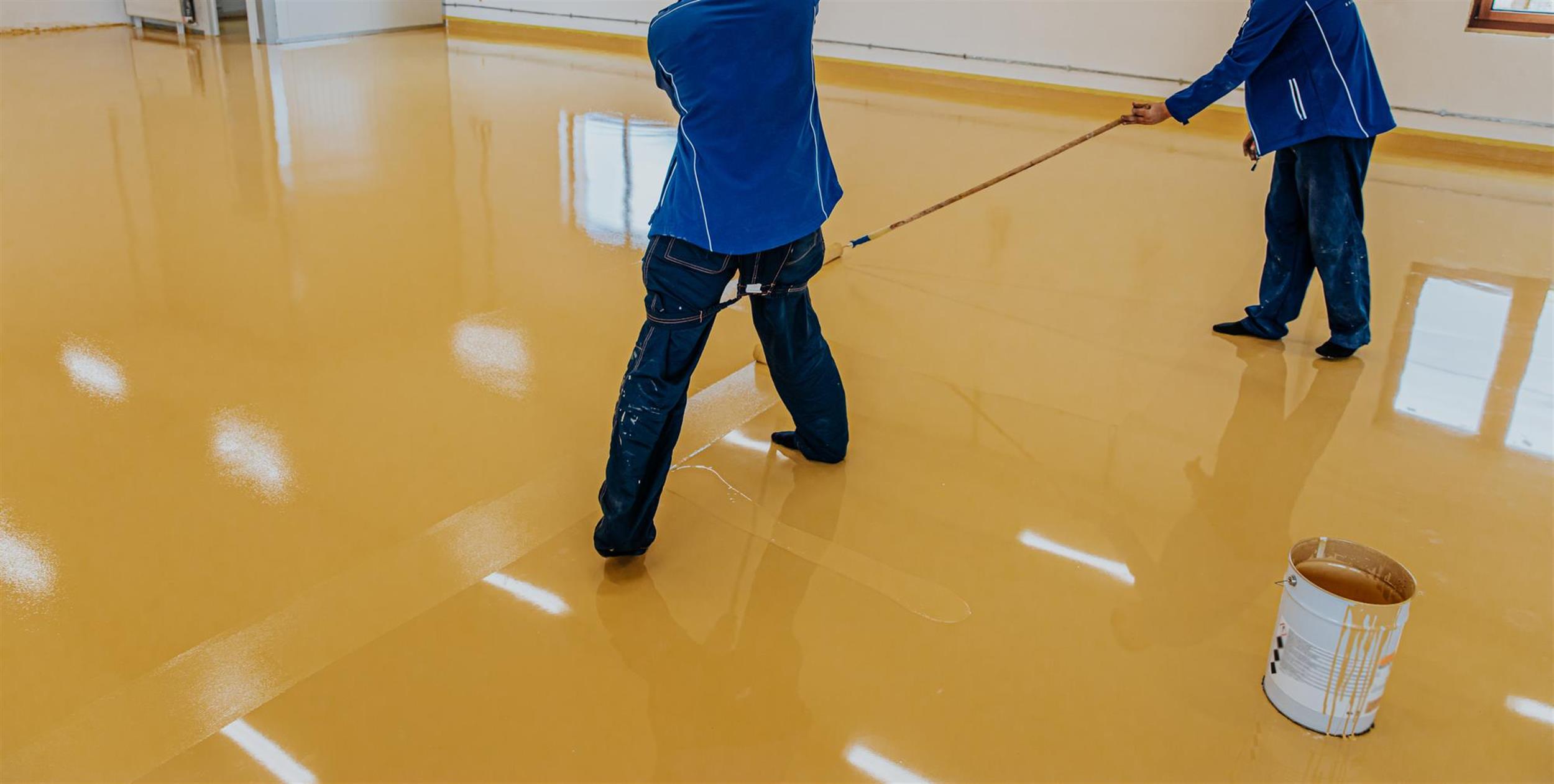 Worker-coating-floor-with-selfleveling-epoxy-resin-in-industrial-workshop-1 color-toners-digital-printer-paint-cmyk-(Large)