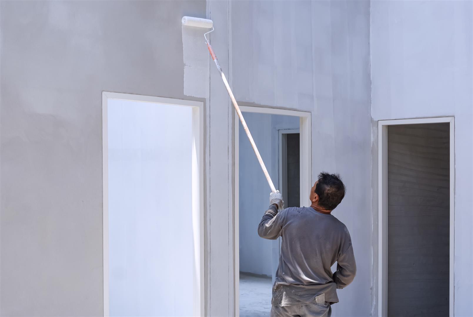 asian-builder-painting-primer-white-color-concrete-wall-inside-house-construction-site (Large)
