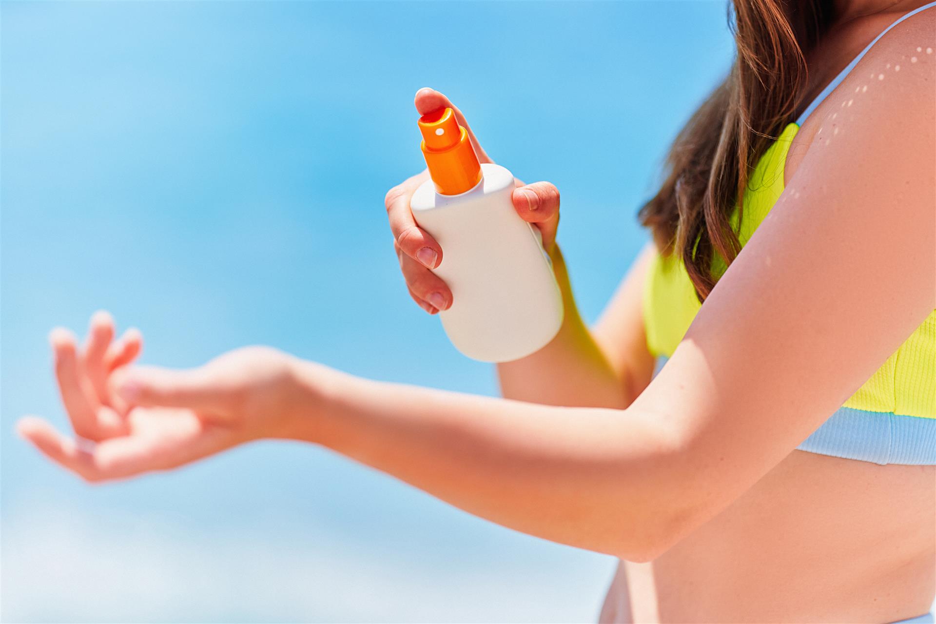 female-applying-holding-white-empty-bottle-blank-sunscreen-lotion-while-sunbathing-beach-by-sea-sunny-summer-day-sun-protection (Custom)