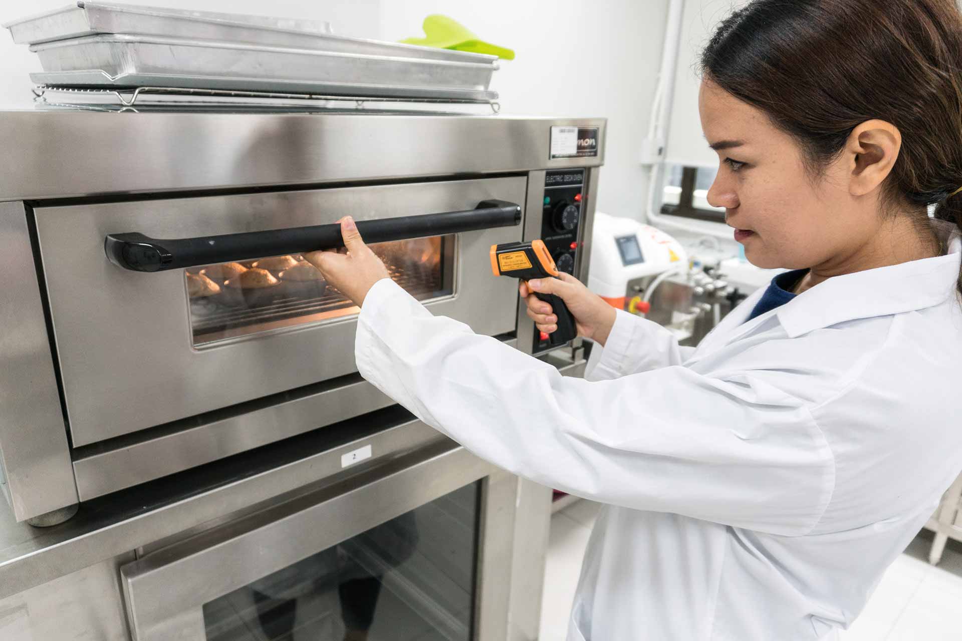 food-lab-baking-equipment food lab technician checking baked goods with equipment