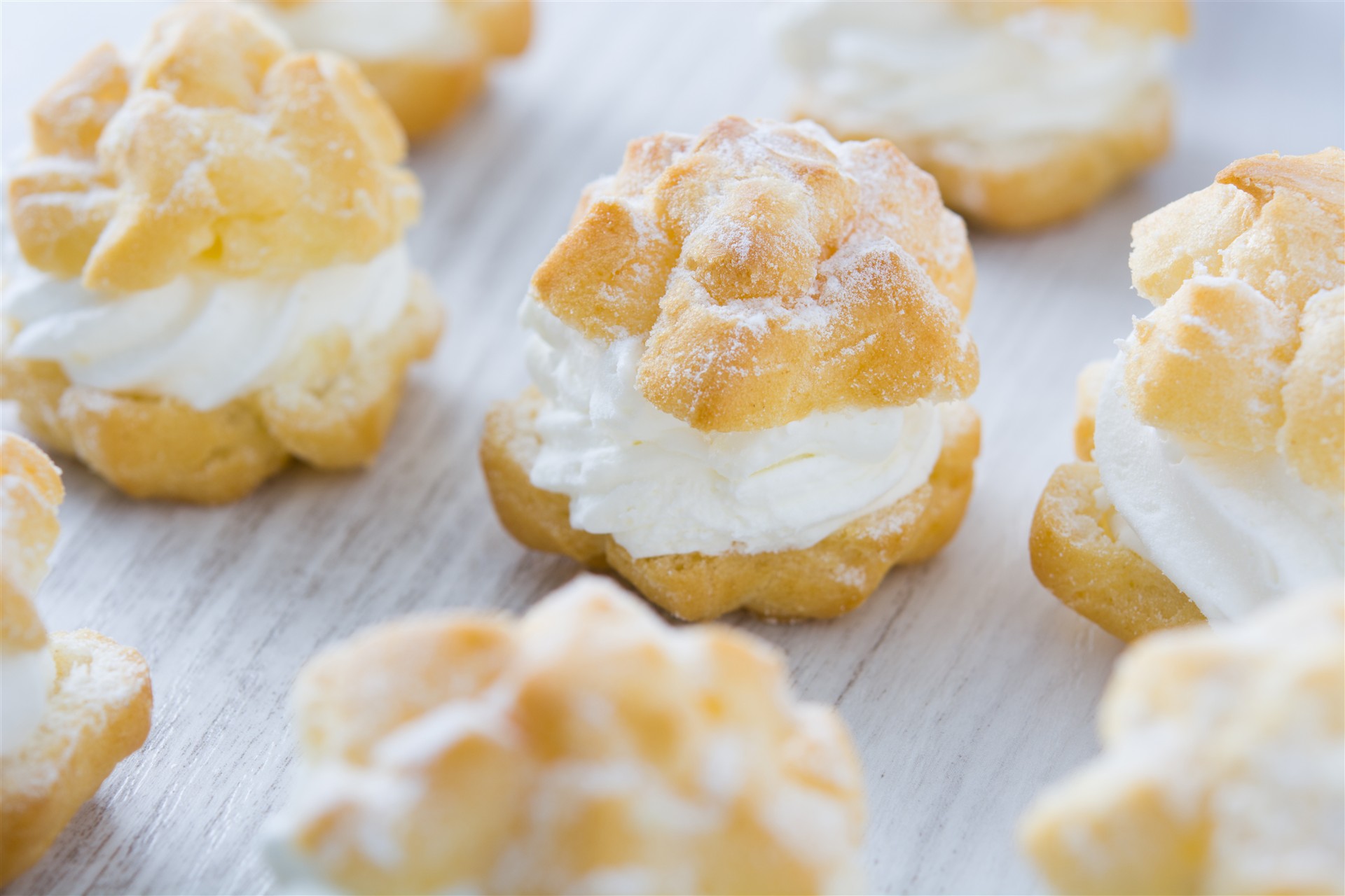 fresh-profiteroles-with-cream (2) pile-cookies-cloth-wooden-table